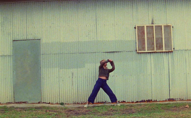 A young woman is dancing outdoors in the day time