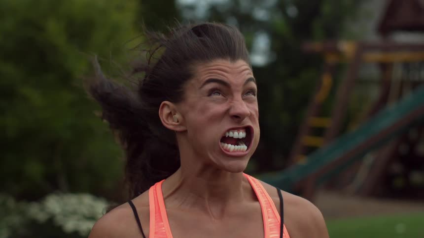 A woman's mouth is being blown wide open in extreme slow motion