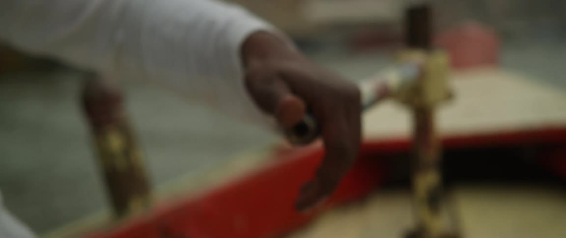 A hand at the helm of a boat steering it