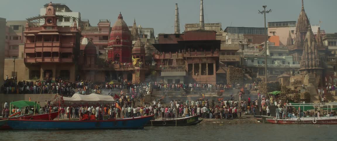 People fill the shore by the city