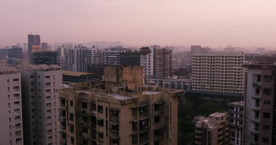 A panoramic view of a tower block with a few derelict buildings on a foggy morning