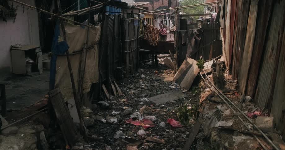 An alley between homes is filled with trash