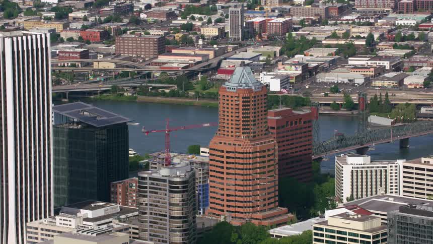 A skyscraper with a pyramidal roof in a tower block near a river