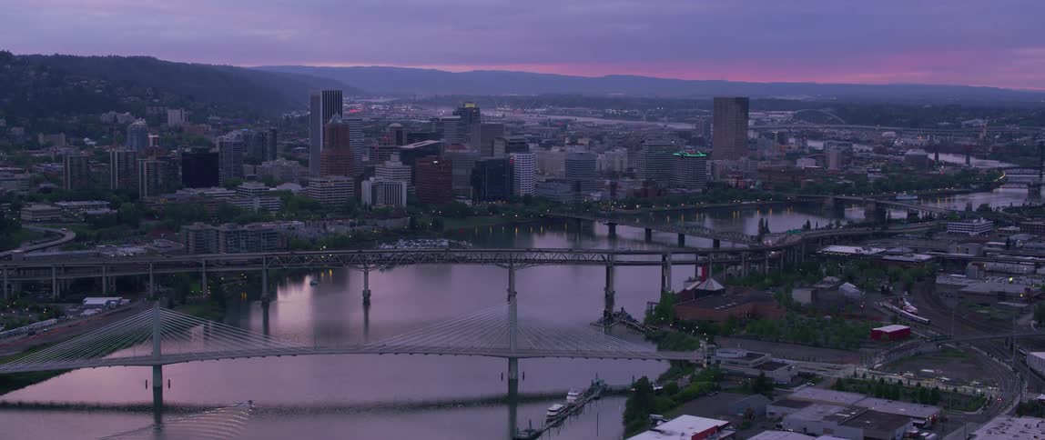 A city by a river crossed by many bridges at dusk