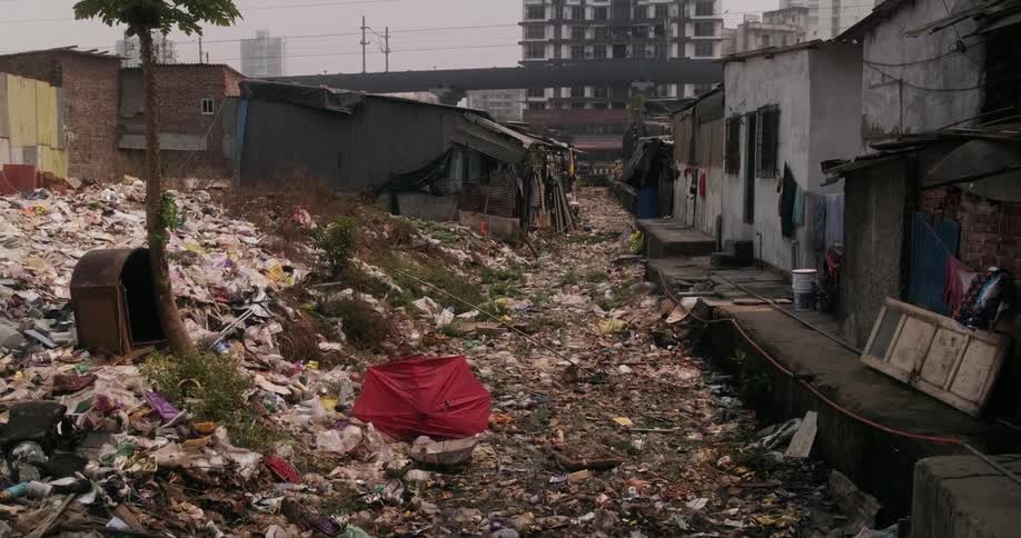 A street in a slum completely covered in garbage