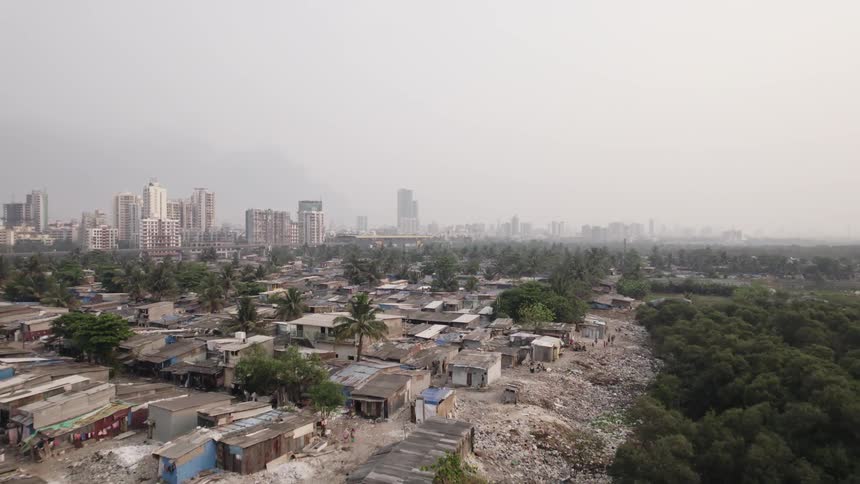 Drone view of a dense forest in a third world country with garbage everywhere and huts for houses