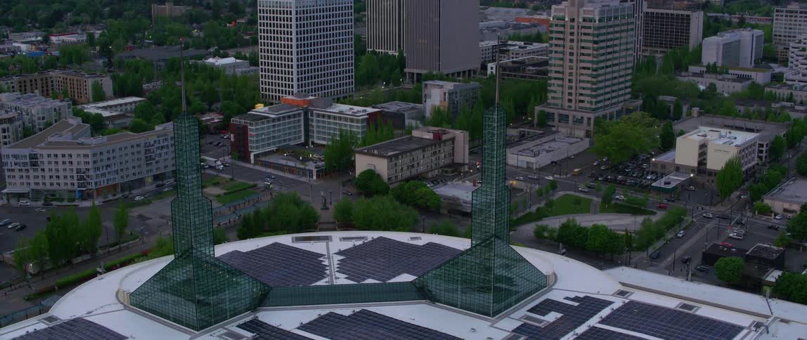 A large two story building with a flat roof covered with solar panels and two glass towers