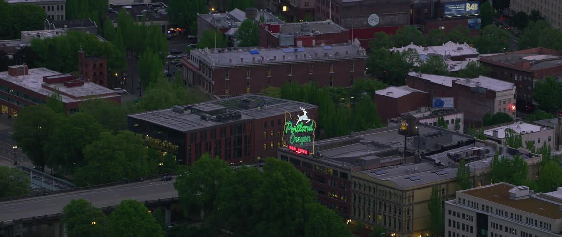 Traffic moves along highways passing near neon sign announcing portland oregon old town