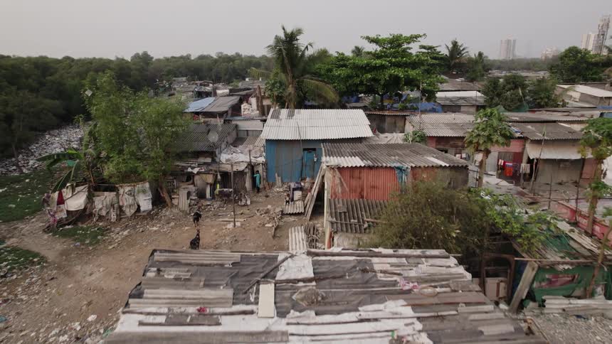 Drone view of a third world country with garbage strewn all over the land and huts for shelter