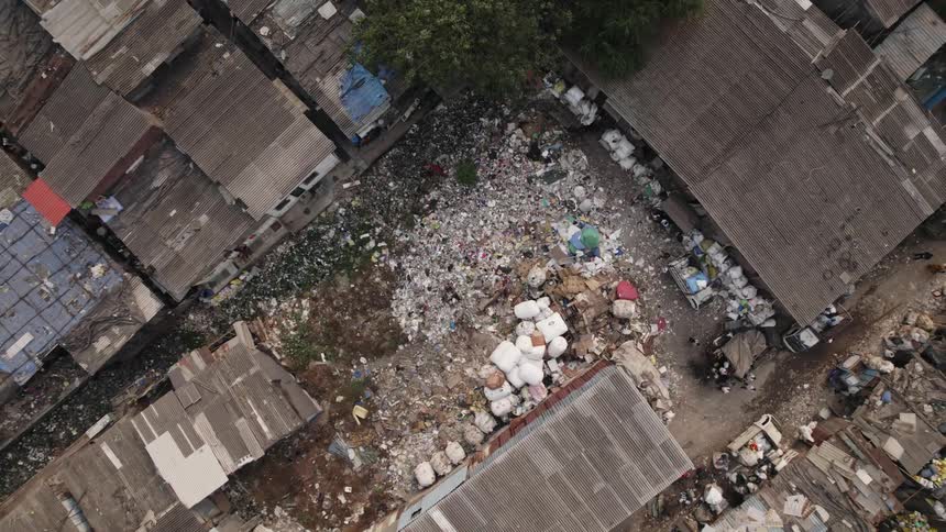 Piles of trash fill the space between buildings