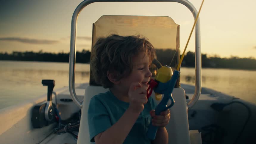 A boy in a canoe in a happy mood playing in an ocean