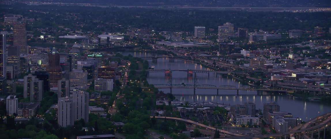 The view is of the downtown area and cars are driving down the highway