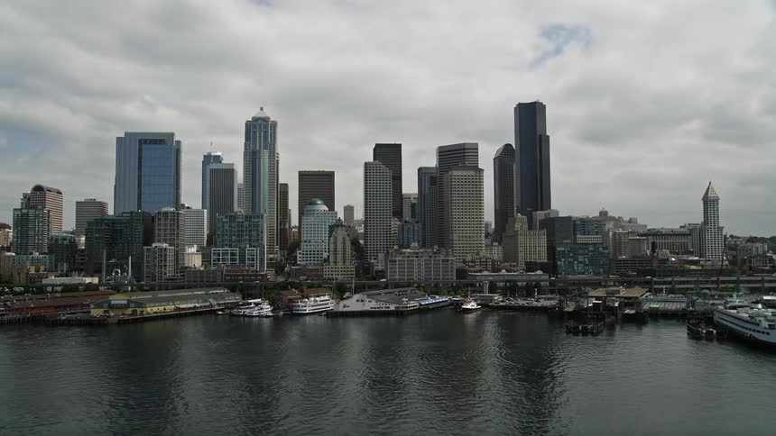 Aerial footage of Seattles waterfront reflecting the skyline and iconic Great Wheel on Pier 57