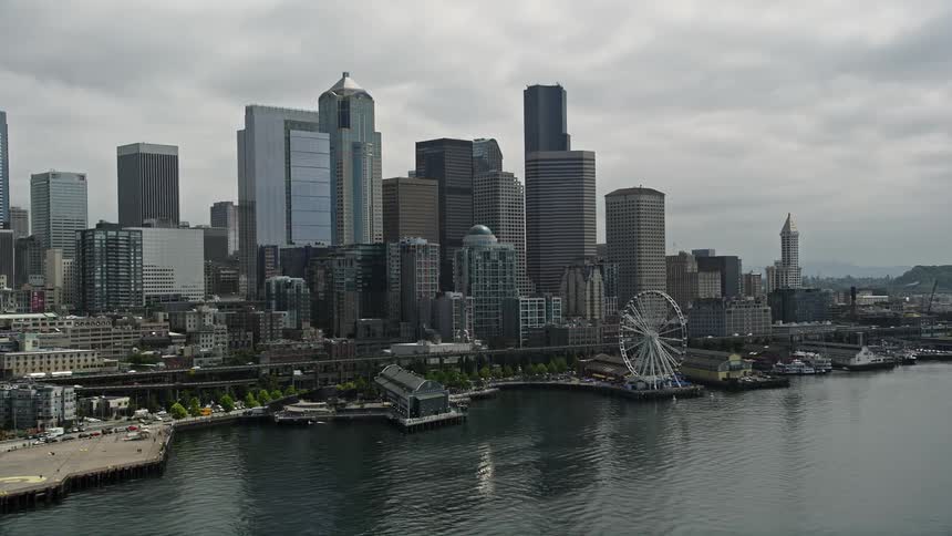 5K aerial footage of Downtown Seattles tall skyscrapers lining the Central Waterfront and docks as seen from Elliott Bay Washington on an overcast day