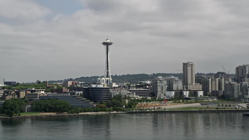 A stunning aerial view of downtown Seattle with the Space Needles reveal while tilting up from the lovely Elliott Bay
