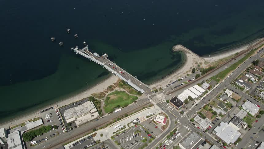 A stunning birds eye view of the Edmonds Passenger Terminal and boats parked at the end of a pier in Washington States sunny harbor