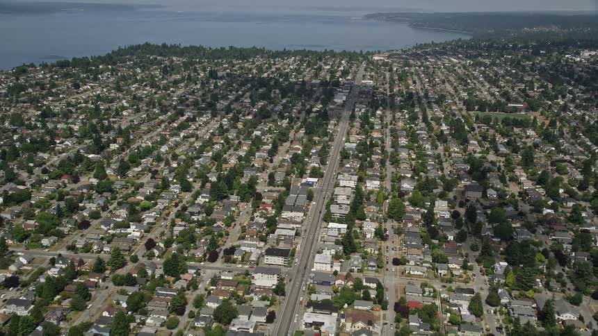 Aerial footage of residential neighborhoods in Ballard Washington with neat rows of homes and partly cloudy skies