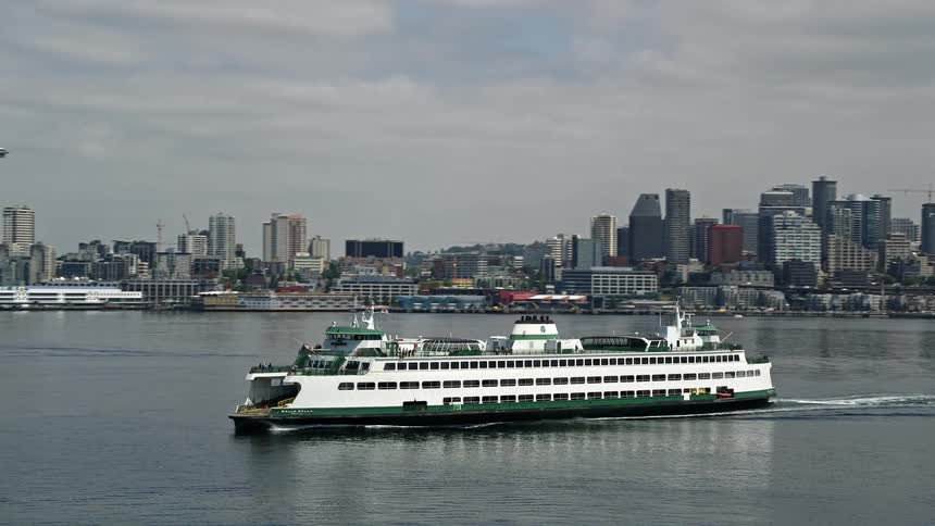 A ferry sails past Seattles skyline and Space Needle while on Elliot Bay