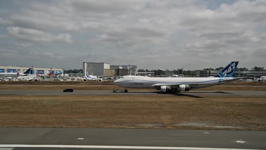 A 747 plane taxis on the runway at Paine Field airport in Washington State during partly cloudy skies
