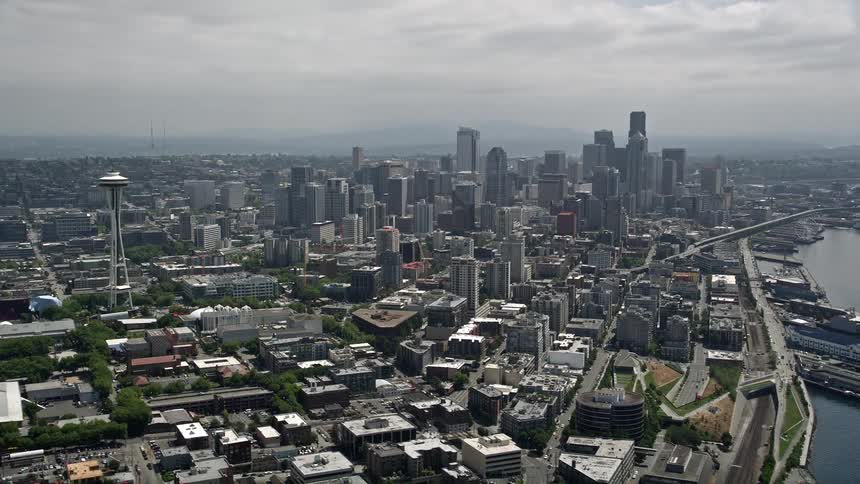Aerial view of Seattles iconic Space Needle and towering skyscrapers in the bustling Downtown area on a partly cloudy day