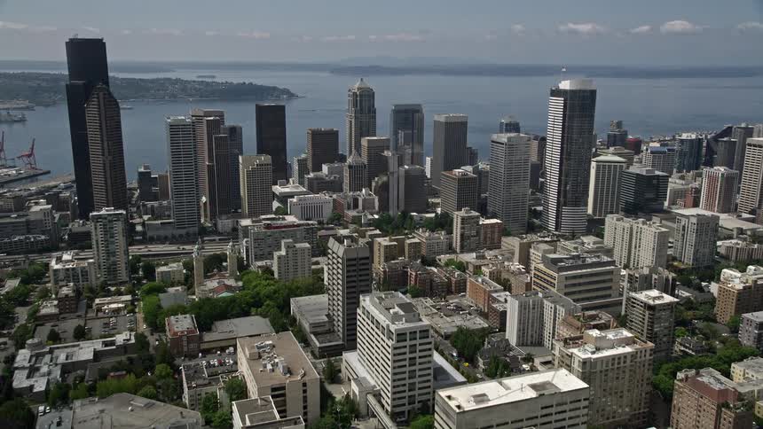 Aerial footage of Seattle University campus and downtown Seattle Washington with stunning views of high rise towers and skyscrapers under sunshine