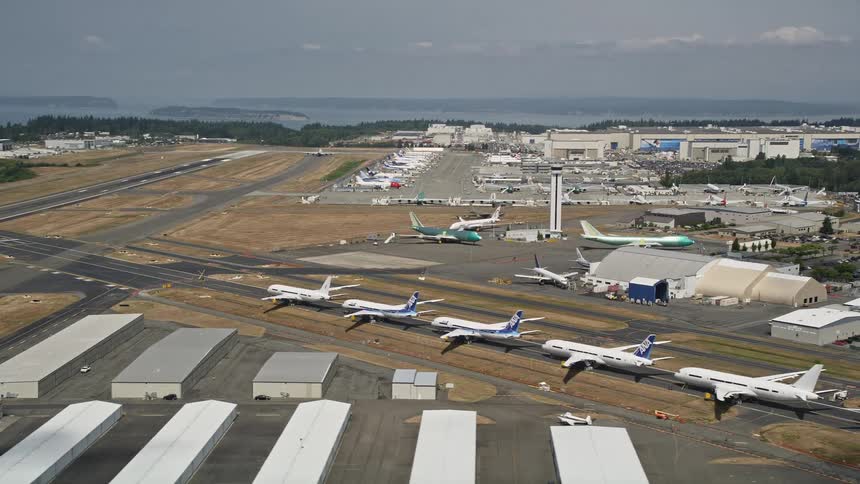 Aerial footage of six parked airliners at Paine Field revealing the Boeing Factory in Washington