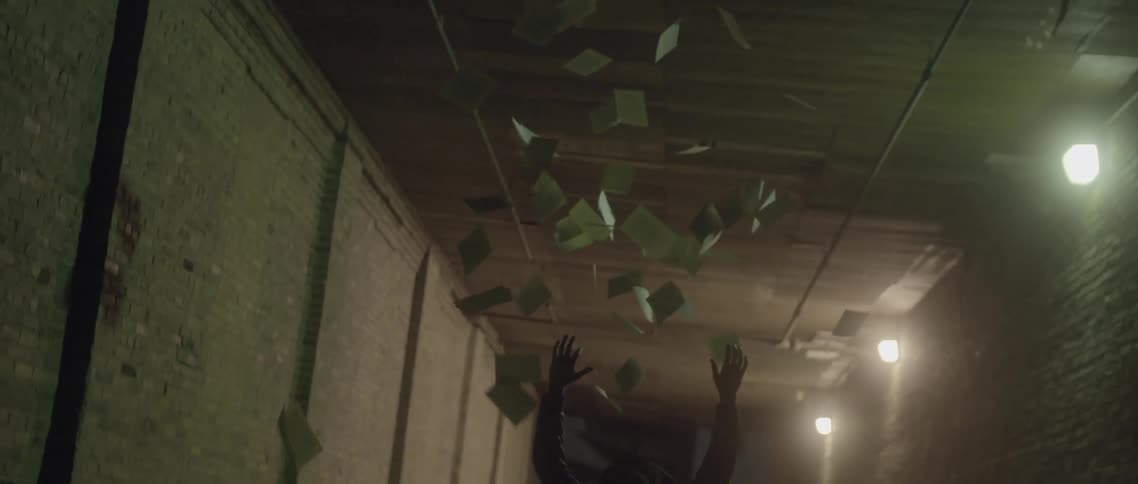 Person throws up small squares of paper in a tunnel at night