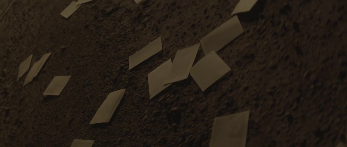 Papers are scattered on a dirt floor