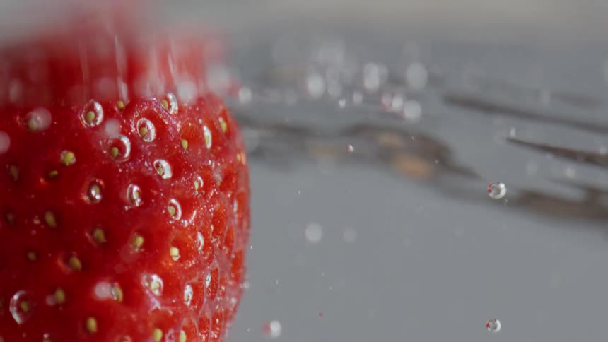 A single strawberry floats in water