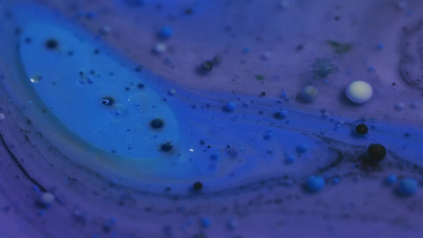 A gooey liquid oozes and flows in several shades of blue