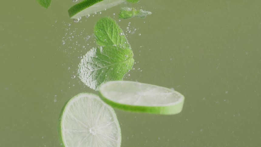 Lime slices fall in cocktail