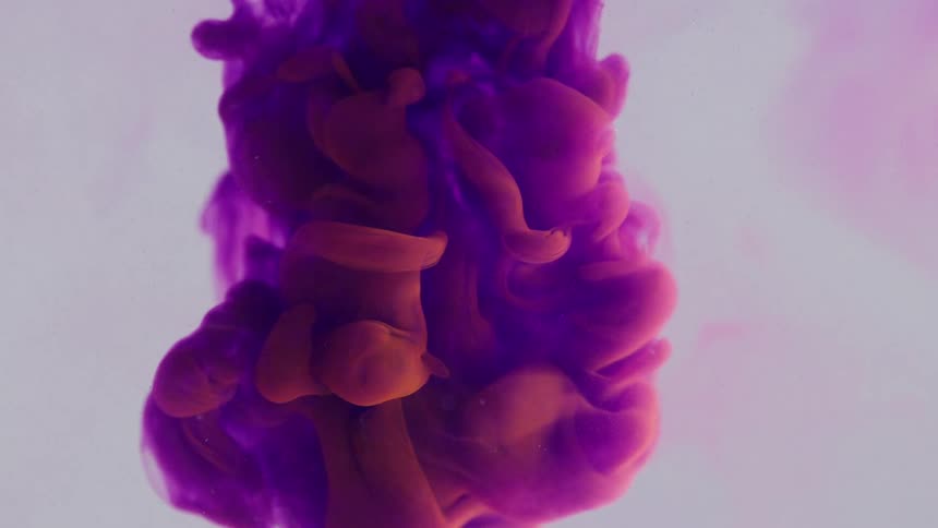 A thick pink and red cloudy substance moves down from above and becomes more purple as it grows