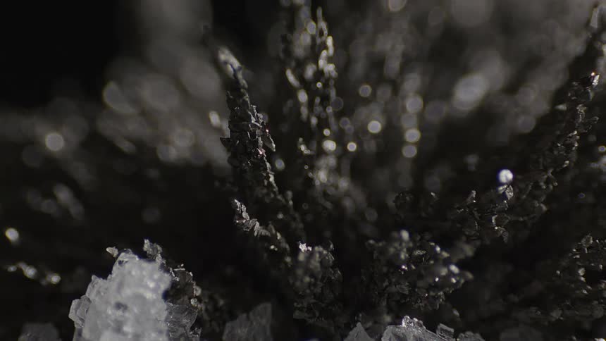 Light reflects off a gray crystal