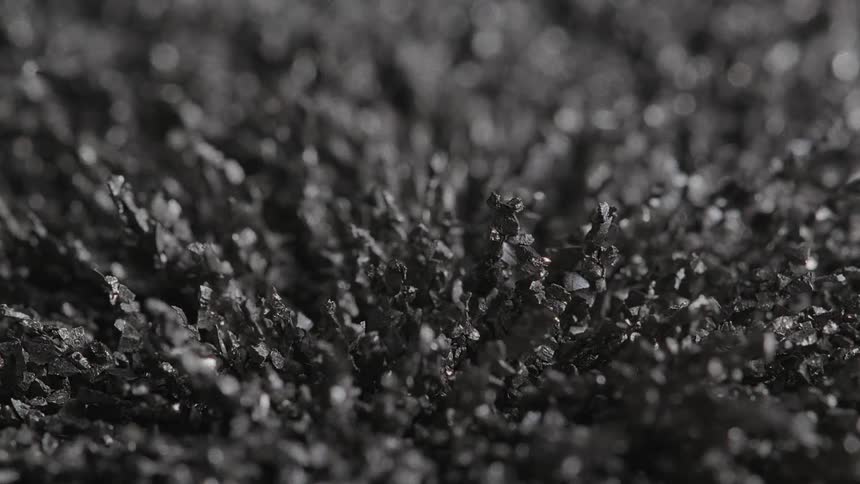 Black crystalline formations turn from left to right over time