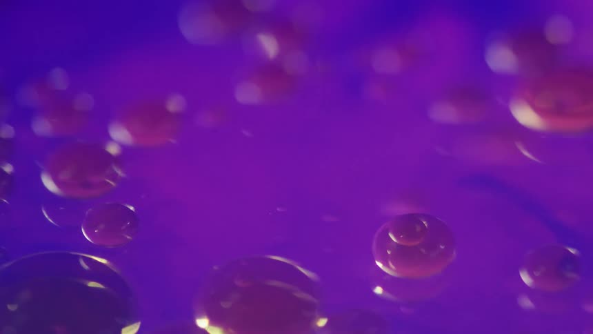 Blue liquid changes to purple as purple bubbles float to the surface