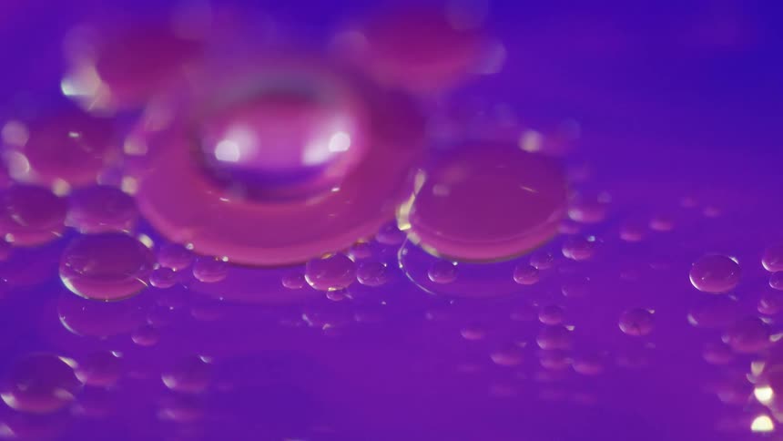 Groups of purple bubbles are not moving within blue liquid
