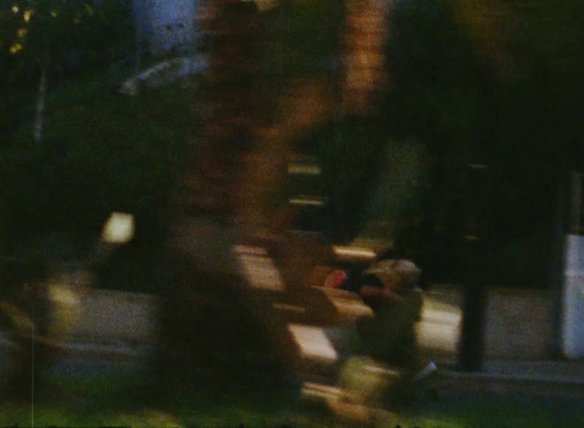 A young man speeding downhill on a skateboard lowering himself to gain speed