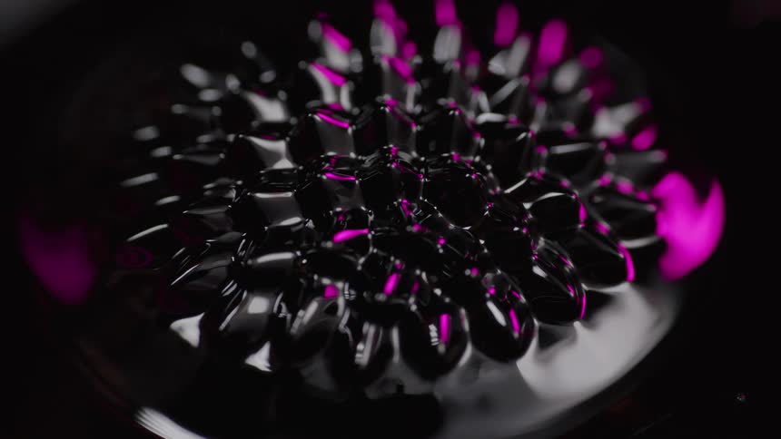 Light gleams along circular rim surrounding silver and purple nodules in a starburst formation