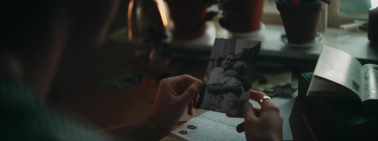 A man reading a letter and looking at a picture
