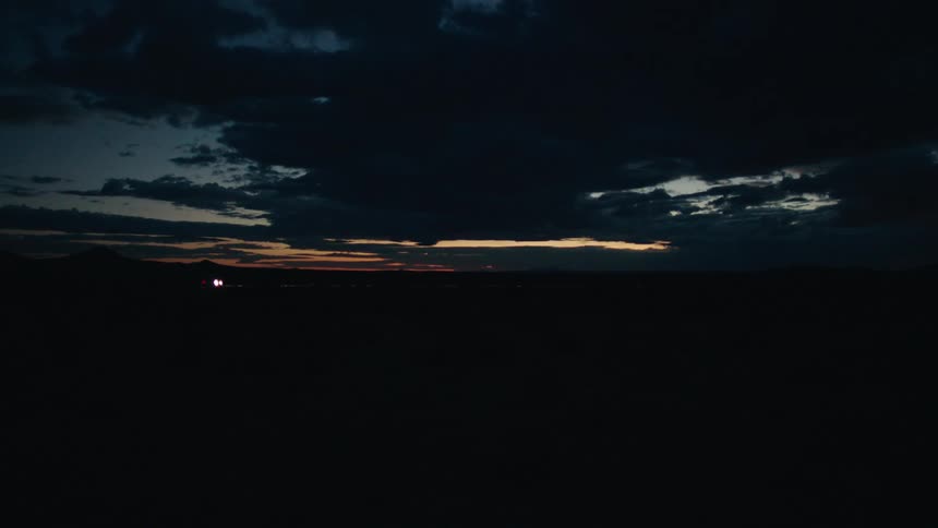 A vehicle drives past an open field