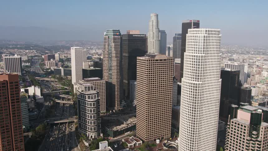 An aerial view of the Ritz-Carlton and the downtown skyscrapers in Los Angeles with heavy traffic on the I-110 freeway