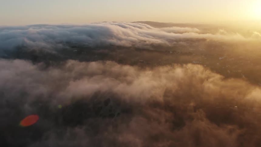 Aerial view of the marine layer over hills during sunset in Studio City California