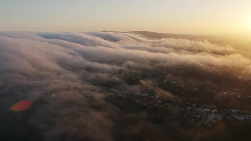 Flying over Studio City California during sunset this aerial 4K footage captures the beautiful marine layer above the hills