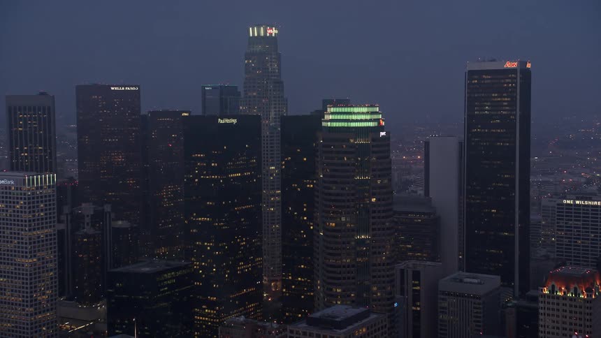 Approaching Downtown Los Angeles at twilight aerial footage captures the citys towering skyscrapers and illuminated buildings