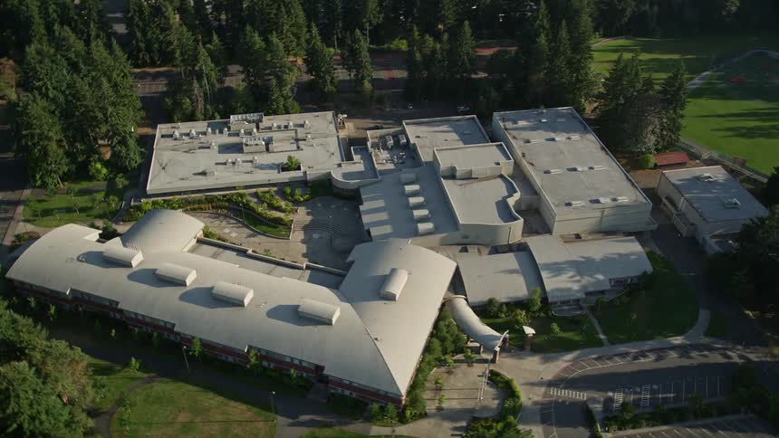 Aerial footage of Interlake High School in Bellevue Washington showcasing the school campus surrounded by trees in a suburban setting under sunny skies