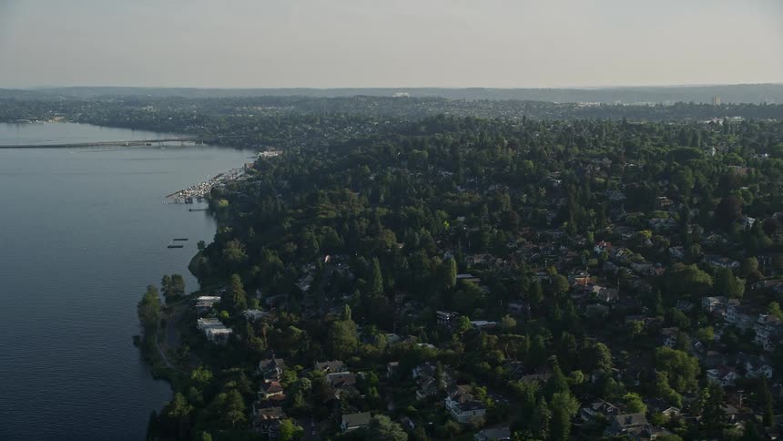 Aerial footage of lakefront homes and suburban neighborhoods by Lake Washington in Madrona Washington showcasing the sunny residential side of the suburban community in the Pacific Northwest