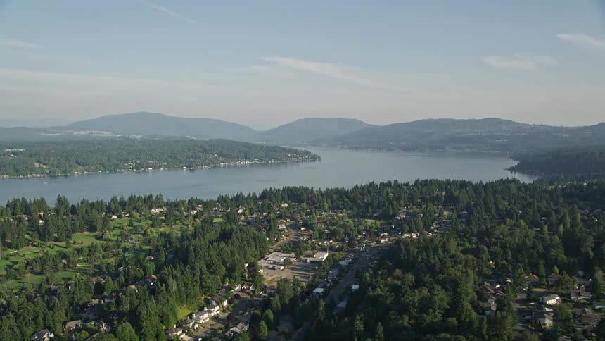 Aerial footage of Lake Sammamish with suburban neighborhoods in Bellevue Washington showcasing the scenic shoreline and residential houses