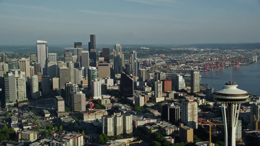 Approach the famous Space Needle and Seattle Center from Elliott Bay orbit to reveal the downtown skyline of Seattle Washington on a sunny day