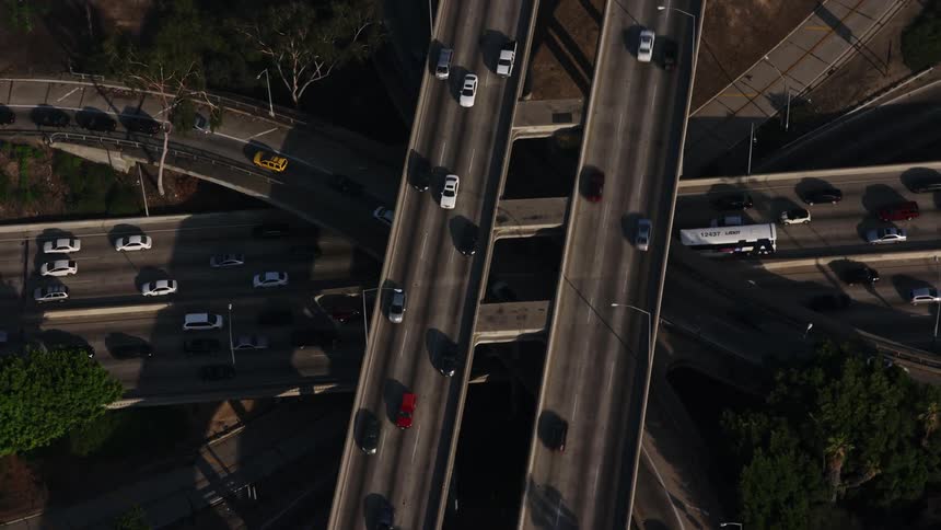 Approaching heavy rush hour traffic at I-110 and 101 interchange in downtown Los Angeles from an aerial perspective