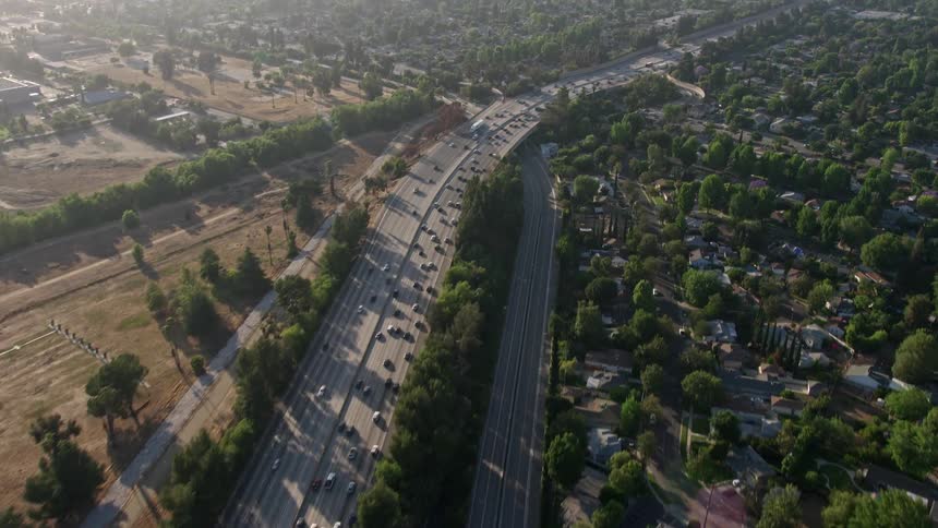 A birds eye view of heavy traffic on I-405 pans across suburban neighborhoods in Van Nuys CA